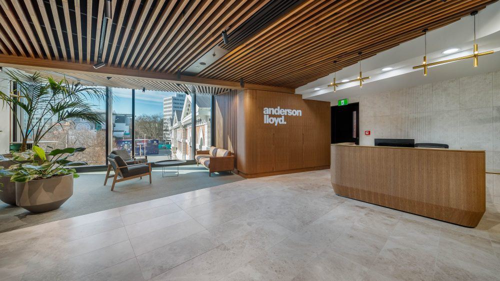 Anderson Lloyd reception with curved timber desk, timber slat ceiling and full-height glazing over central Christchurch