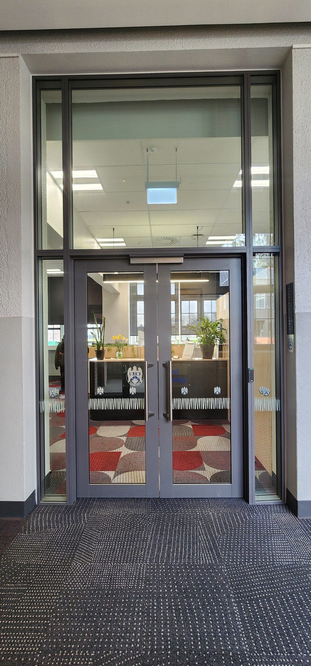Glazed aluminium office front with operable window in the Christchurch Boys High School main hall